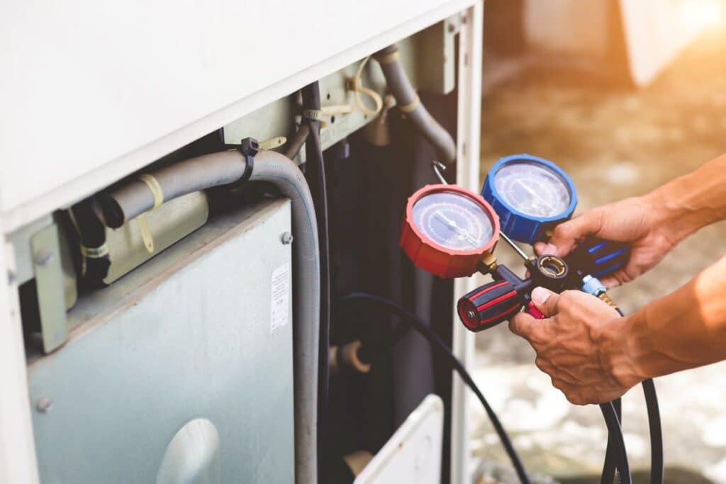 echnician using vacuum sensor gauges to check pressure in an HVAC system