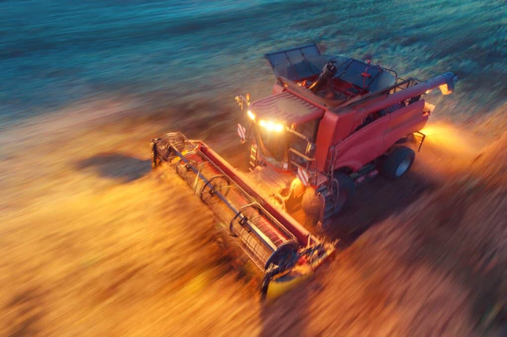 Ein landwirtschaftliches Fahrzeug bei Dunkelheit mit eingeschalteter Beleuchtung