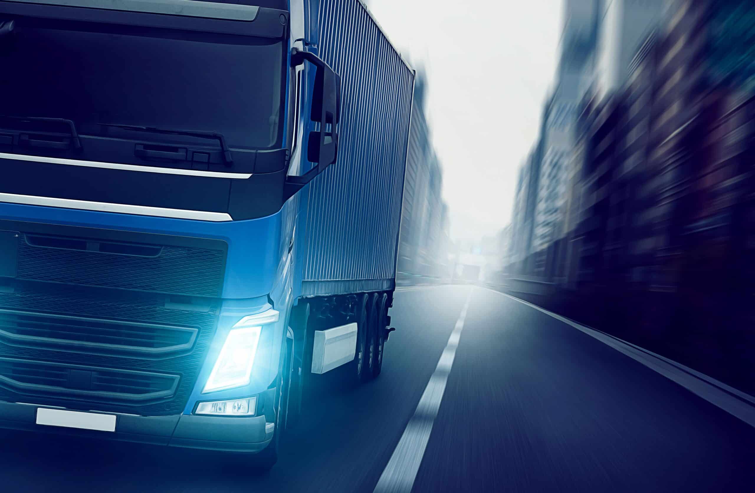 Moderner Lkw mit aktivem Zusatzscheinwerfer Fernlicht fährt durch die Stadt