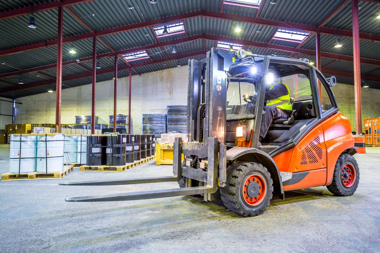 Gabelstapler mit Fahrer transportiert schwere Lasten in Industriehalle