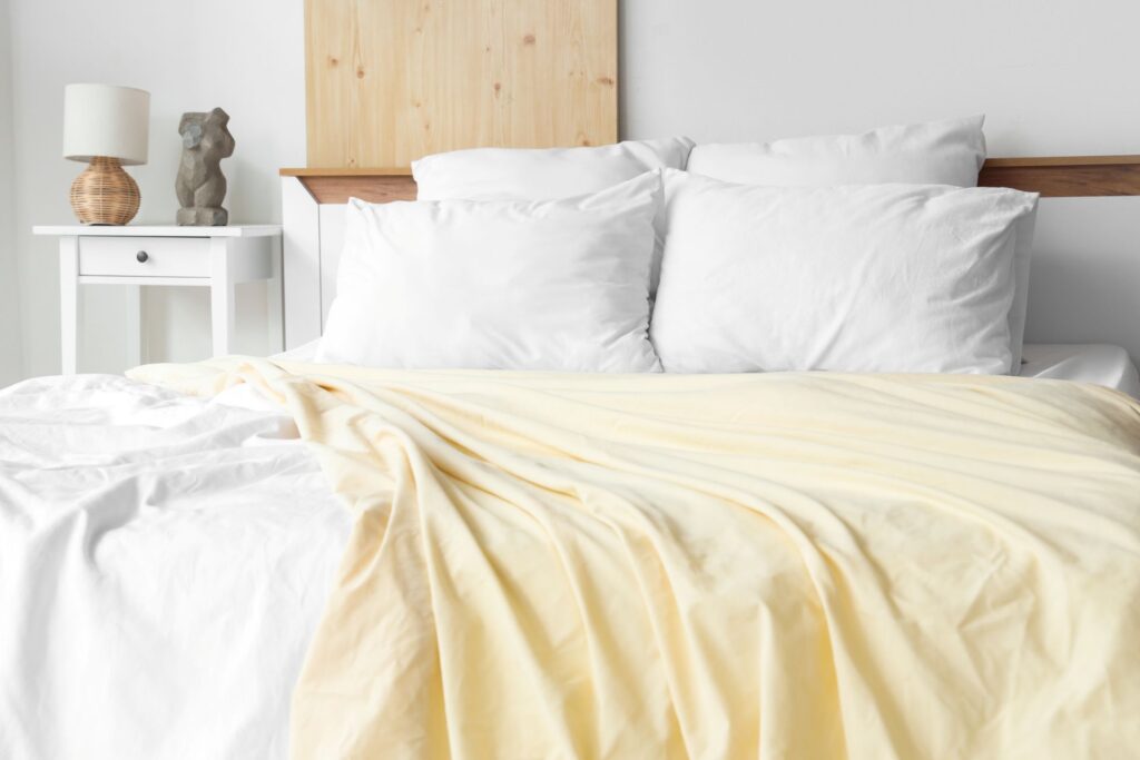 modernes schlafzimmer mit jersey bettwaesche in gelb und weiss – stilvoll eingerichtet mit naturmaterialien