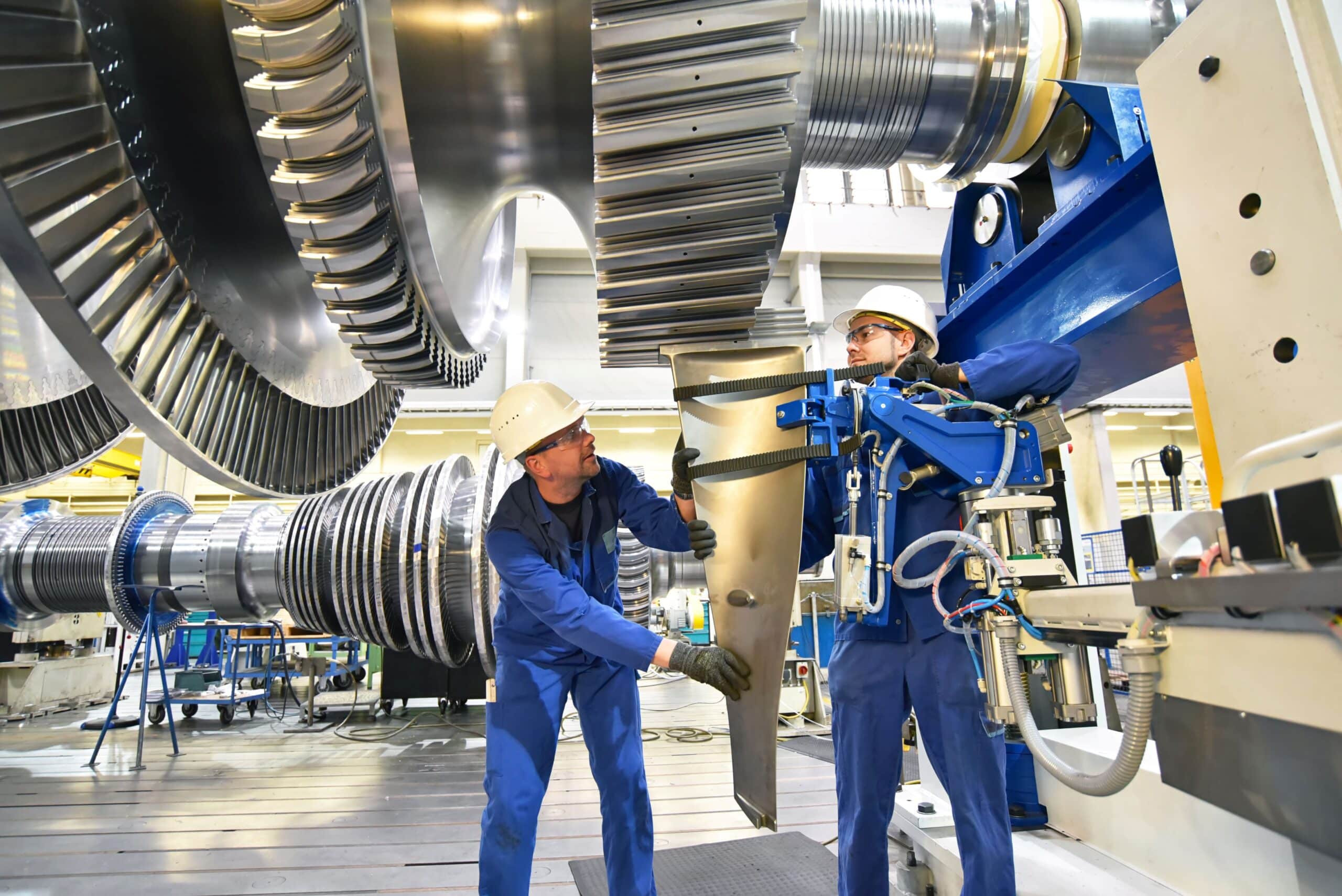 Zwei Industrietechniker arbeiten mit Präzision an einer Turbinenanlage