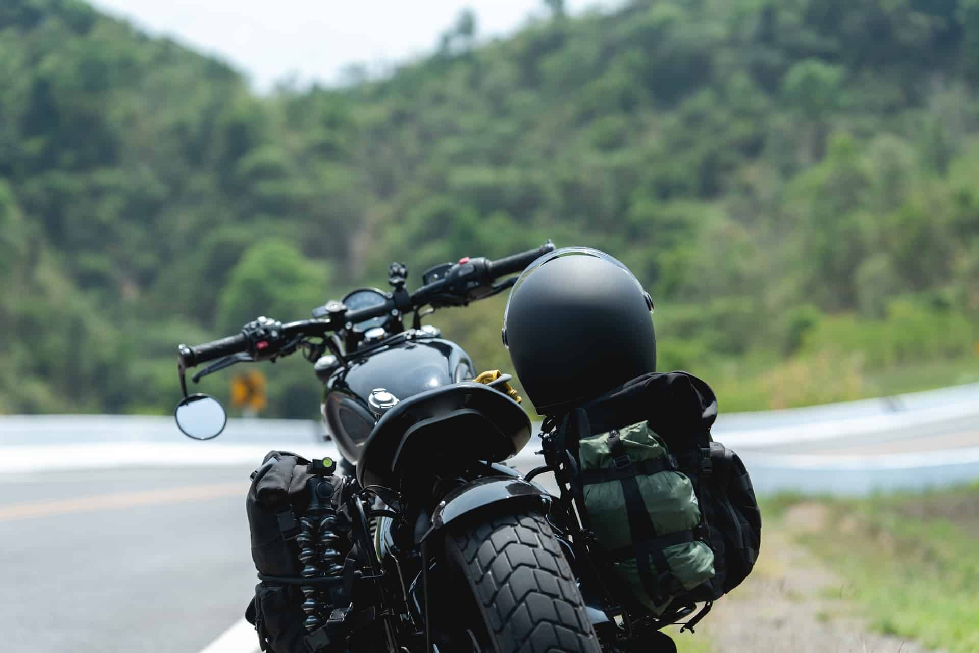 Motorrad mit Helm und Gepäck am Straßenrand | Satteltaschen