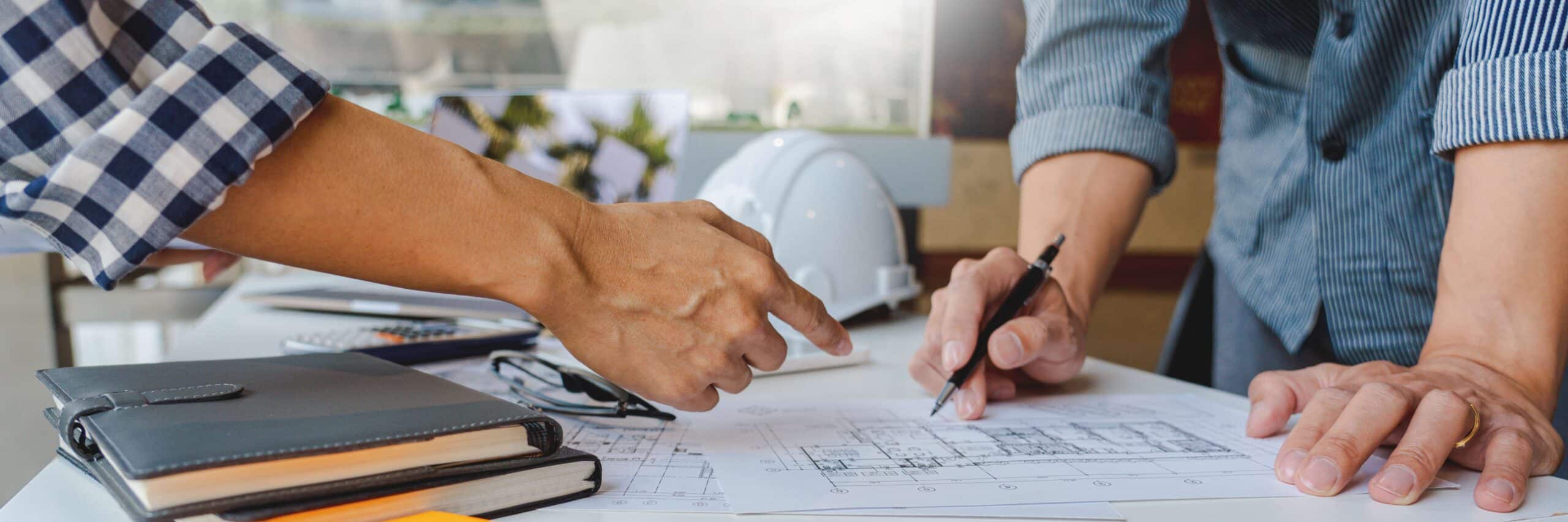 HeruntergeladenKooperation Unternehmensdesigner im Büro arbeiten an einem neuen Projekt Planung Blueprint Design auf der Baustelle am Schreibtisch im Büro.