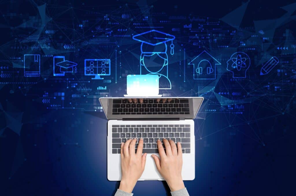 Hände auf Laptop mit digitalen Lernsymbolen | E-Learning Content